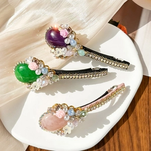 Baroque hair clips set with emerald cat-eye stones, pearls, and rhinestones in elegant style