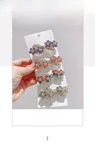 Detail of four crystal flower hair clips in purple and pink with alloy spring clips