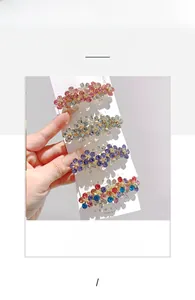 Dettaglio di quattro mollette a molla a forma di fiore con strass colorati brillanti