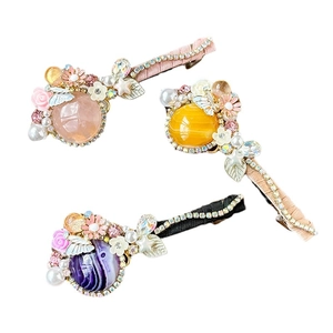 Set de barrettes baroques avec pierres oeil de chat, perles et feuilles sur fond blanc