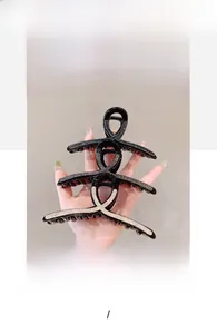 Dettaglio di tre eleganti fermagli per capelli con strass scintillanti dal design incrociato