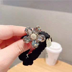 Gros plan sur un chouchou floral en cristal noir avec un pendentif en métal doré poli