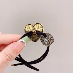 Detailed close-up of a high-elasticity hair tie with a crystal heart and cube charm
