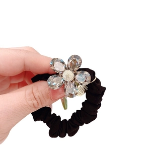 Chouchou noir élastique orné d'une grande fleur en cristal et breloque dorée