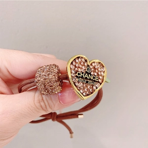 Detailed close-up of a brown elastic hair tie with heart-shaped sparkling rhinestones