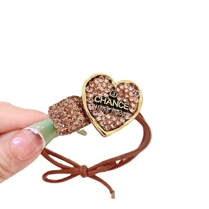 Brown elastic hair tie featuring rhinestone heart and square charms with gold finish