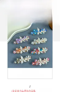 Détail de huit barrettes papillon en alliage avec des strass colorés en différentes teintes