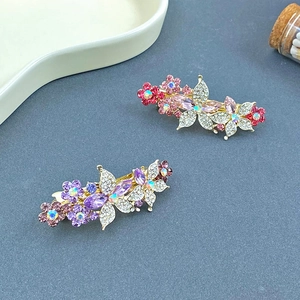 Gros plan de barrettes élégantes fleurs et papillons avec strass roses et violets