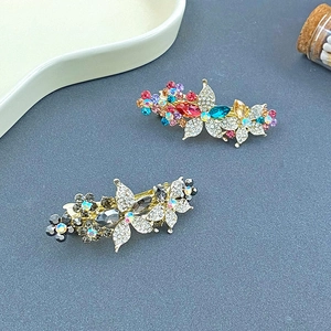 Détail rapproché de barrettes à cheveux à strass étincelants en formes de fleurs et papillons