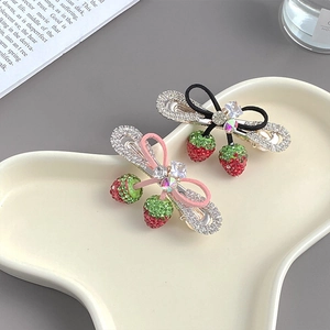 Lot de deux barrettes fraise avec strass et nœuds en ruban sur plateau blanc