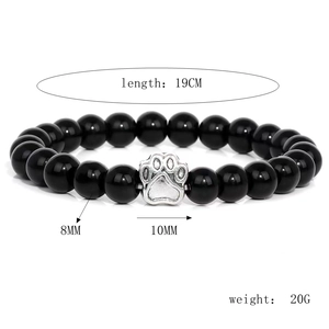 Detail showing 8mm black volcanic stone beads and 10mm silver dog paw charm on a bracelet