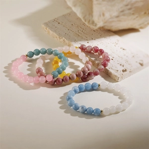 Detalle de pulseras de piedra natural de 8mm con cuentas doradas y redondas