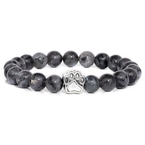 Macro detail of natural grey stone beaded bracelet featuring a silver dog paw charm
