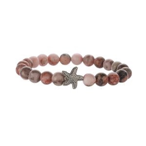 Macro detail of natural pink zebra jasper beaded bracelet with silver starfish charm