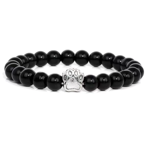 Macro view of 10mm black polished beads with silver paw print charm detail