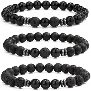 Detail of beaded bracelet set featuring black onyx, lava stone, and metallic spacers