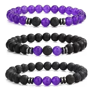Macro shot of three beaded bracelets with purple agate, black matte, and lava rock beads