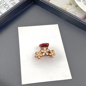 Eleganter Mini-Haarclip aus bernsteinfarbenem Harz mit drei goldenen Strass-Blumenmustern