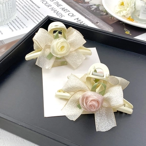 Detailansicht beige Haarklammern mit Organza-Schleifen und zarten Rosen auf einem Tablett