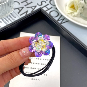 Detailed close-up of a floral K9 crystal hair tie with purple facets and elastic band