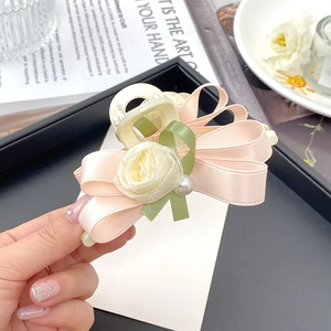 Detail von elegantem rosa Mesh-Bogen Haarklammer mit Rose und Perlenakzenten