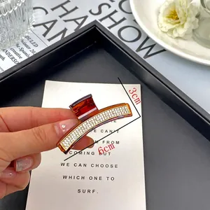 Elegante pinza per capelli ambra con due file di strass bianchi scintillanti decorativi