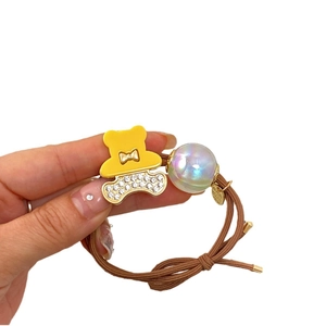 Elastic hair tie with a yellow rhinestone bear charm and a colorful pearl bead decoration