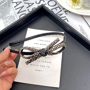 Elegant black velvet headband with double crystal bowknot and shimmering metallic finish