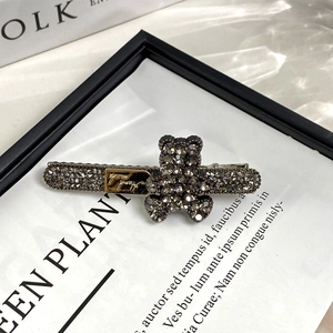 Détail de la pince à cheveux ours avec strass gris foncé et plaque dorée décorative