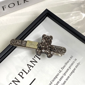 Détail d'une pince à cheveux ours avec strass gris et plaque dorée faite main