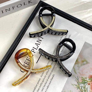 Three-piece rhinestone hair claw set in black and amber colors with cross-twist design