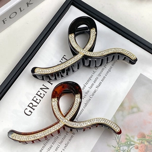 Detail of black and tortoiseshell claw clips with sparkling rhinestone wave patterns