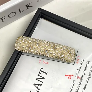 Detailed view of rhinestone and pearl hair clip with 7.5cm by 1.8cm size measurements
