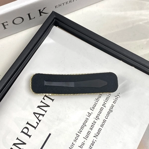 Detail showing elegant black velvet hair clip with golden chain trim on art background