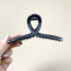 Grosse pince à cheveux noire avec strass bleus et paillettes, idéale pour les chignons