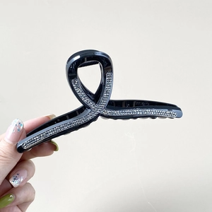 Pince à cheveux noire classique avec strass et design de ruban croisé élégant pour femme