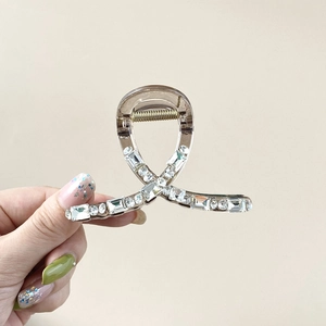 Close-up of champagne crystal hair claw with intricate rhinestone embellishments
