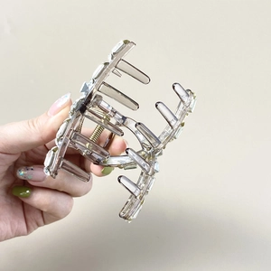 Close-up of a large grey hair claw clip decorated with two rows of rectangular crystals