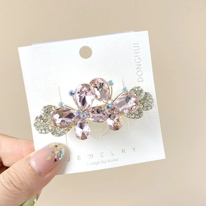 Pince à cheveux papillon en cristal rose et strass sur une carte de présentation bijoux
