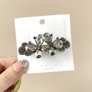 Vue détaillée d'une barrette papillon en cristal sur une carte de présentation bijou