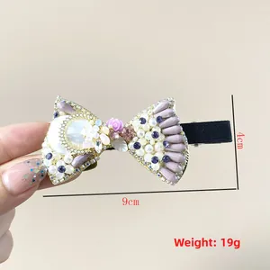 Detailed view of luxury bow hair clip with pearls and rhinestones, size 9cm x 4cm