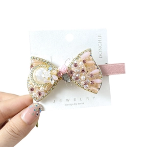 Bow hair clip with pink rhinestones, faux pearls and resin roses on a gold alloy base