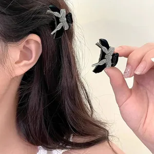 Mini black hair claw clip featuring a silver rhinestone bow decoration for women