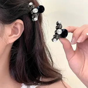 Mini hair claw clip with pearls and rhinestones shown in hair and hand for size comparison