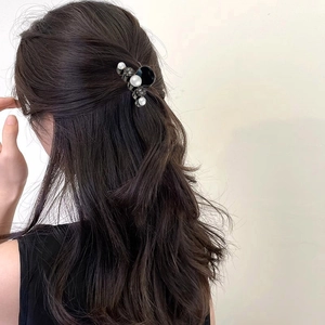 Detail view of mini hair claw clip with pearls and rhinestones on hair bun