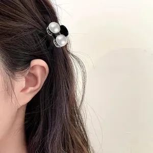 Close-up of elegant mini hair claw clip with faux pearls worn in a princess hairstyle