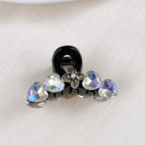 Macro shot of mini hair claw with iridescent heart crystals and floral center detail