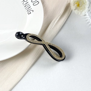 Dettaglio di un fermaglio per capelli a banana con strass su seta elegante