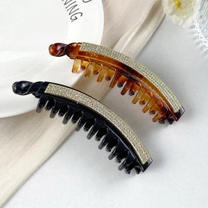 Dettaglio ravvicinato di fermagli per capelli a banana con strass nei colori nero e tartaruga