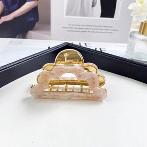 Detail of French cloud hair claw clip with pink marble acetate and gold metal finish